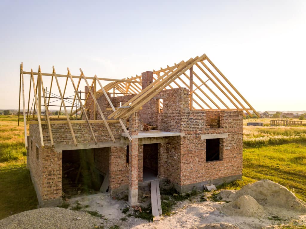 Une vue aérienne d'une maison en construction, mettant l'accent sur le travail complexe de la charpente.