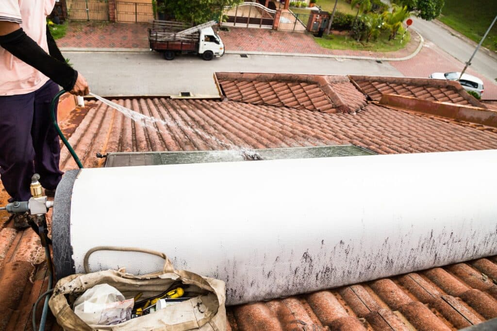 Un charpentier pulvérisant de l'eau sur un toit.